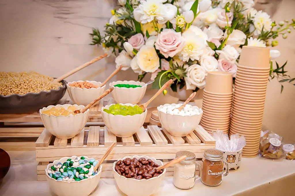 Charming candy bar with bowls of treats, cups, and pastel flowers