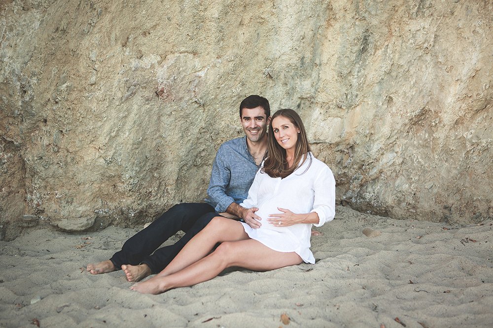 Expectant mom  and Dad Sitting in the sand on El Matador State Beach