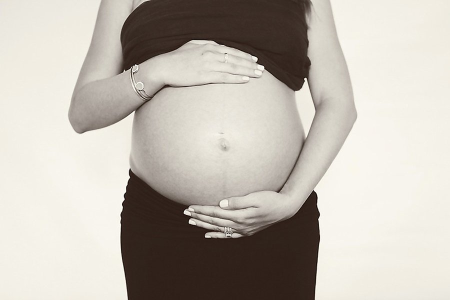 Mommy to be holding her belly baby bump