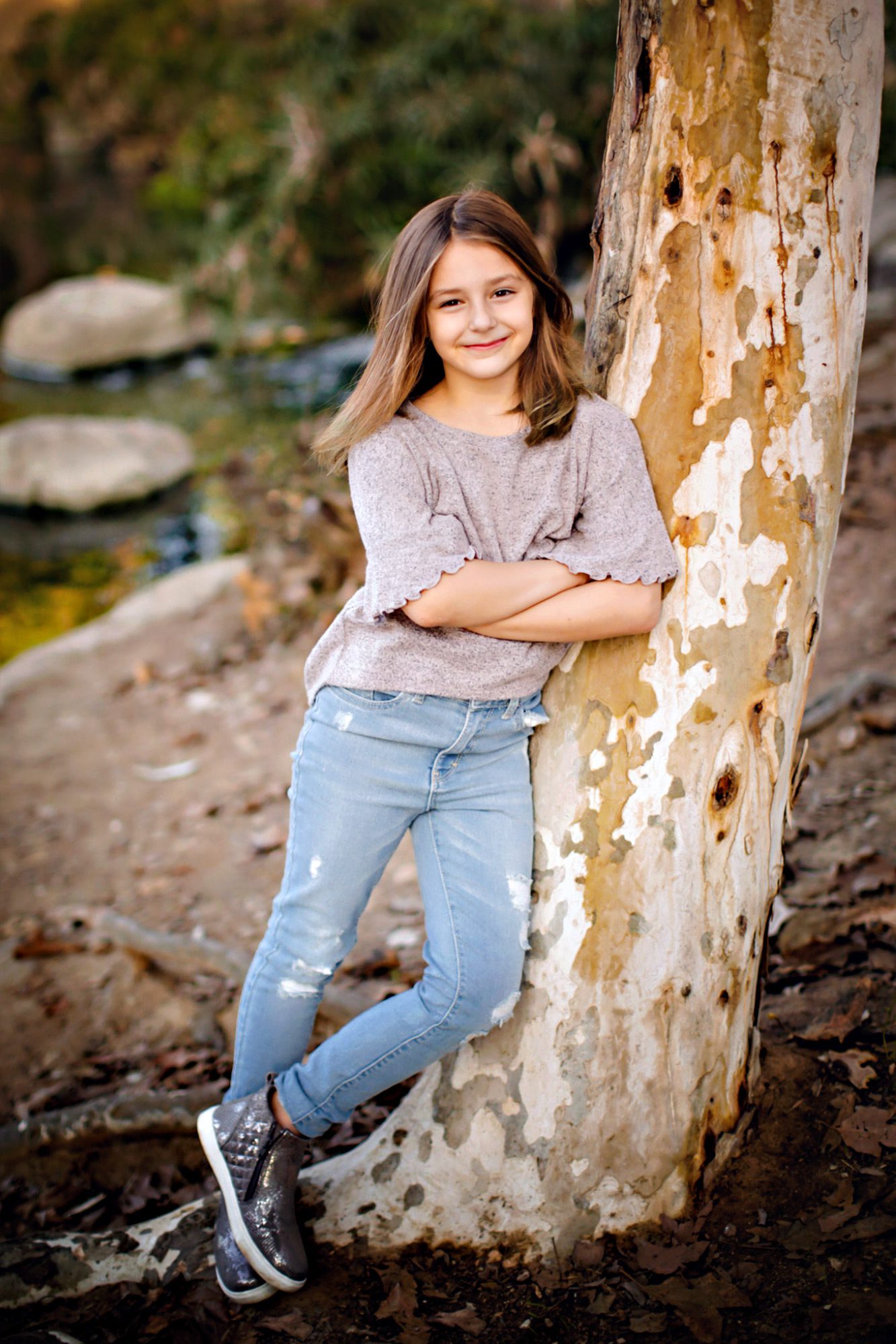 Child leaning against a tree.