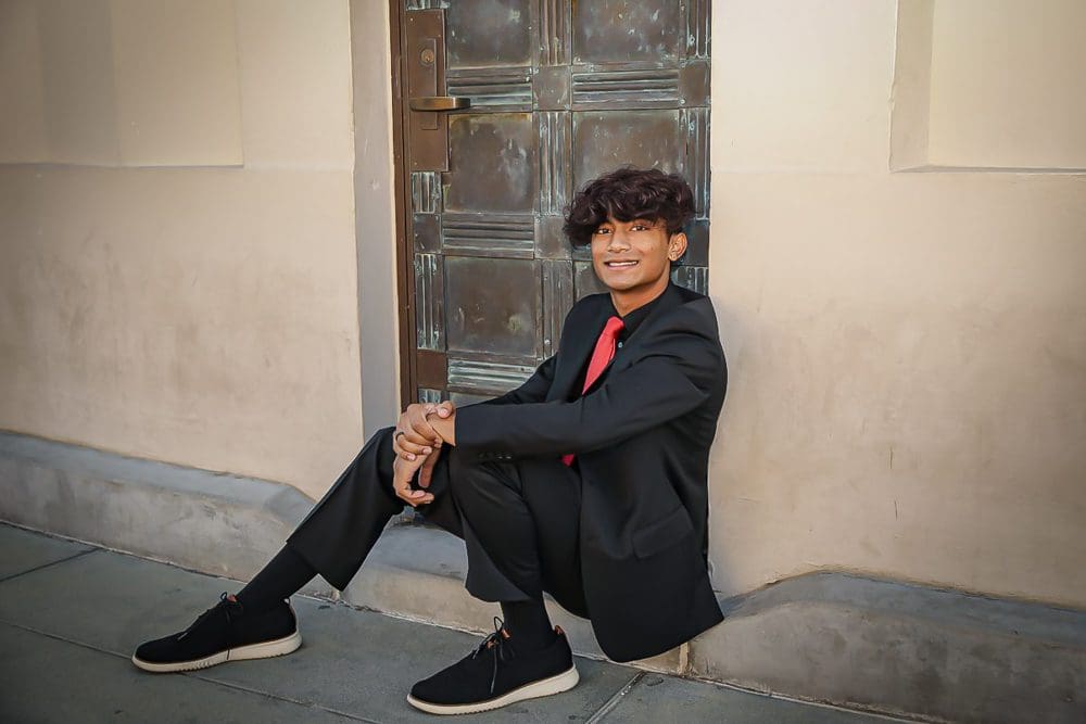 Holiday-Family-Portrait Session-Griffith Observatory-009 Young man in formal attire sitting.