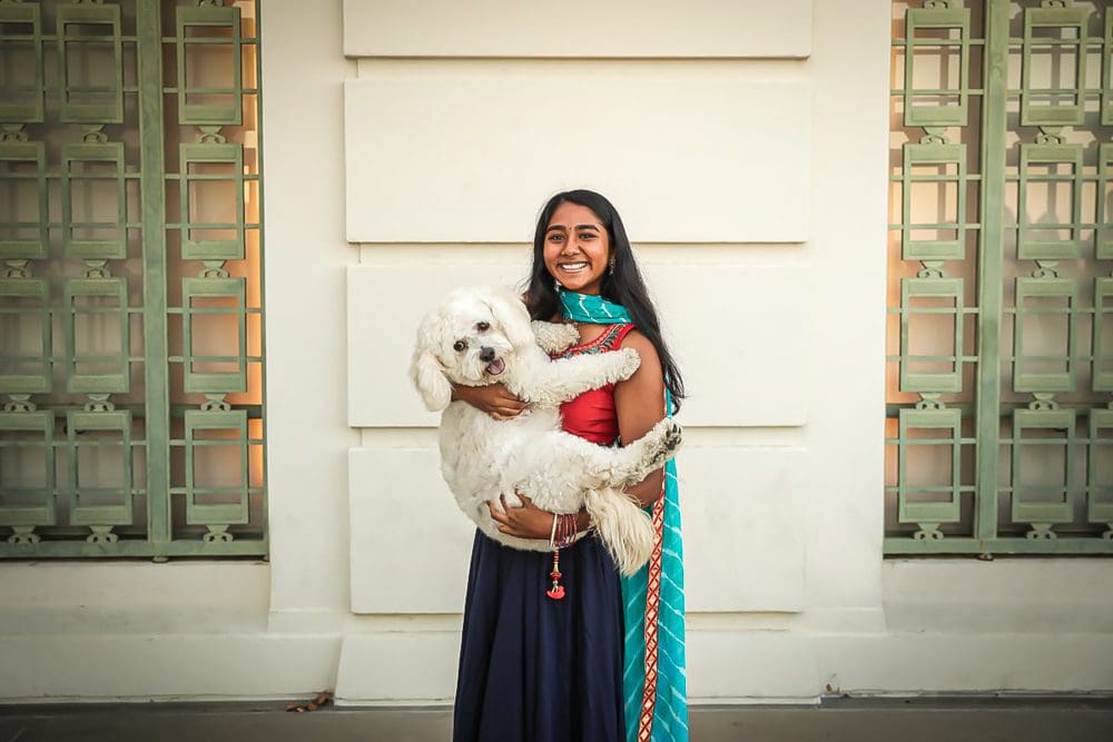 Girl holding a dog in arms.