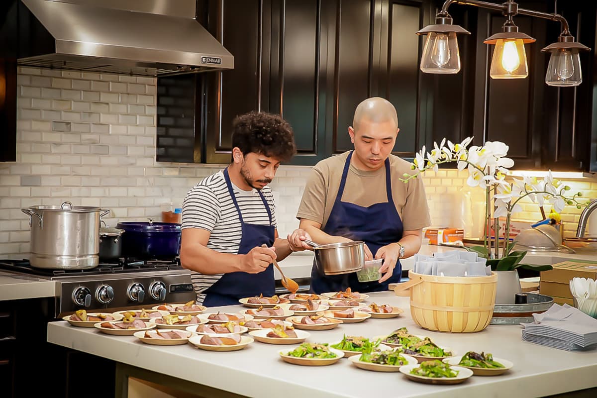 Two chefs preparing gourmet dishes together.